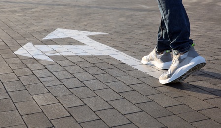 Man going along road with arrows marking, closeup