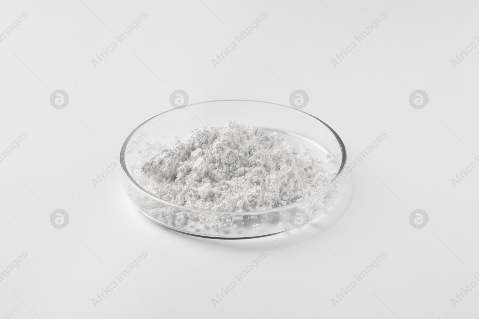 Photo of Petri dish with calcium carbonate powder on white background