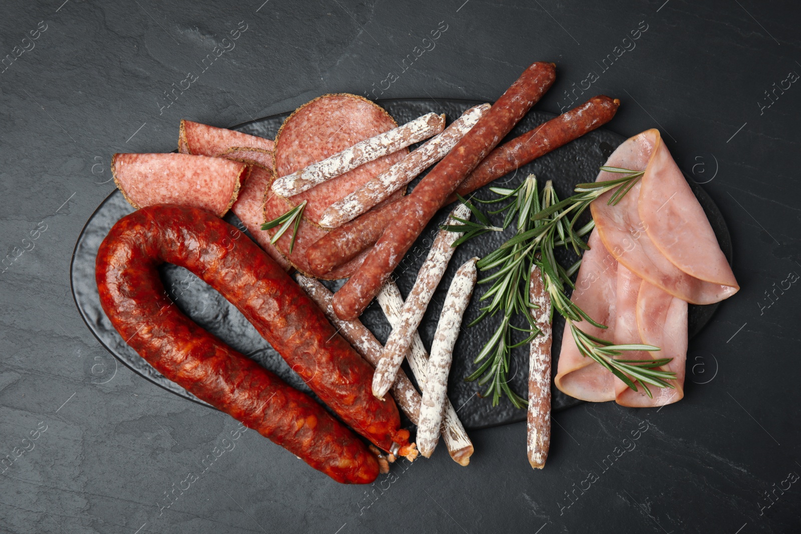 Photo of Different tasty sausages on black table, flat lay