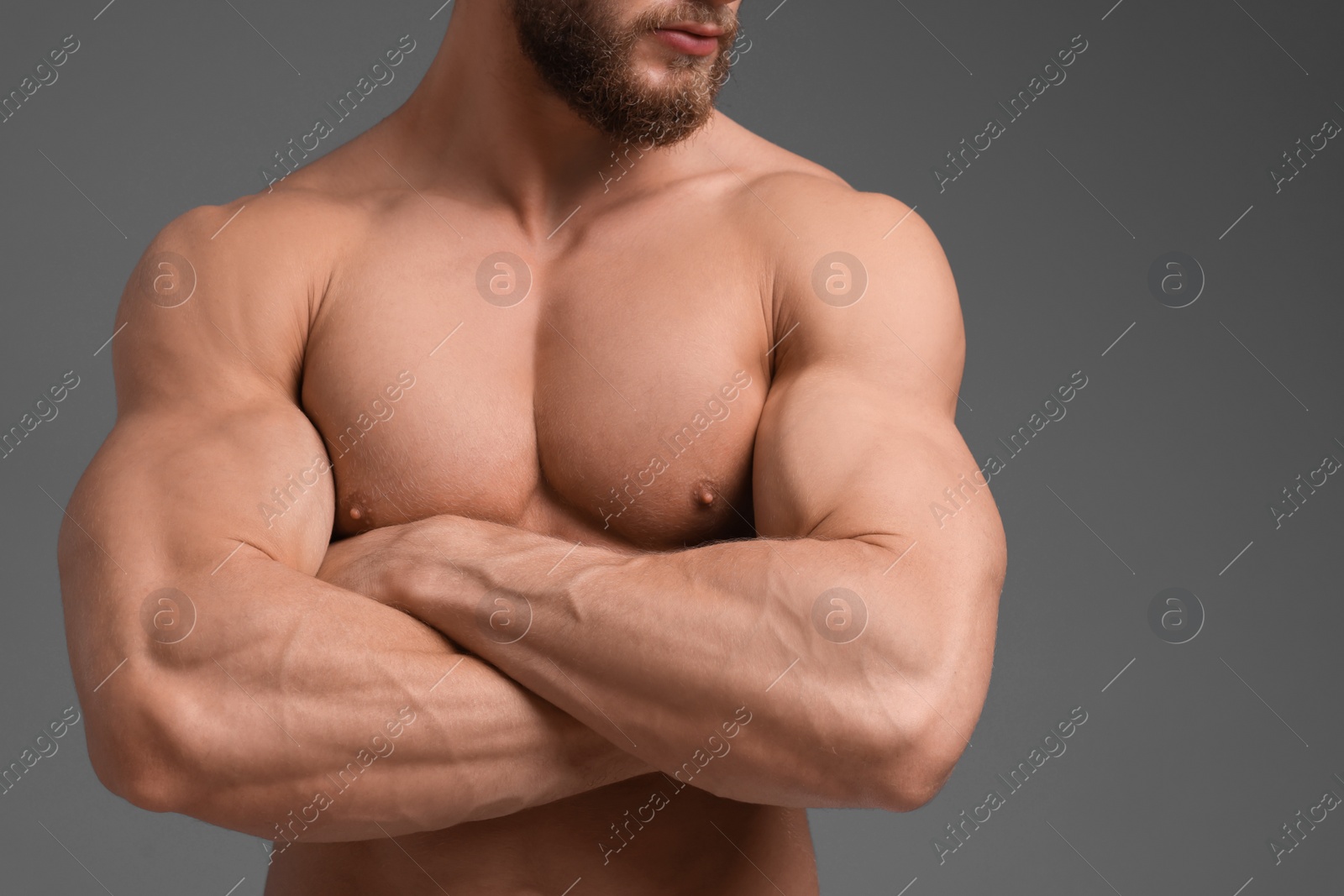 Photo of Muscular man on grey background, closeup. Sexy body