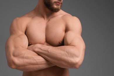 Muscular man on grey background, closeup. Sexy body