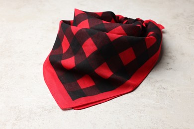 Tied red checkered bandana on white table