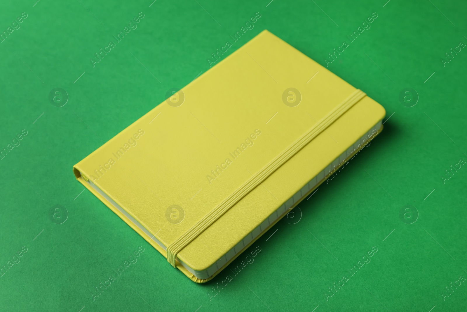 Photo of New stylish planner with hard cover on green background