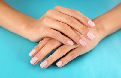 Photo of Closeup view of woman with beautiful hands on color background. Spa treatment