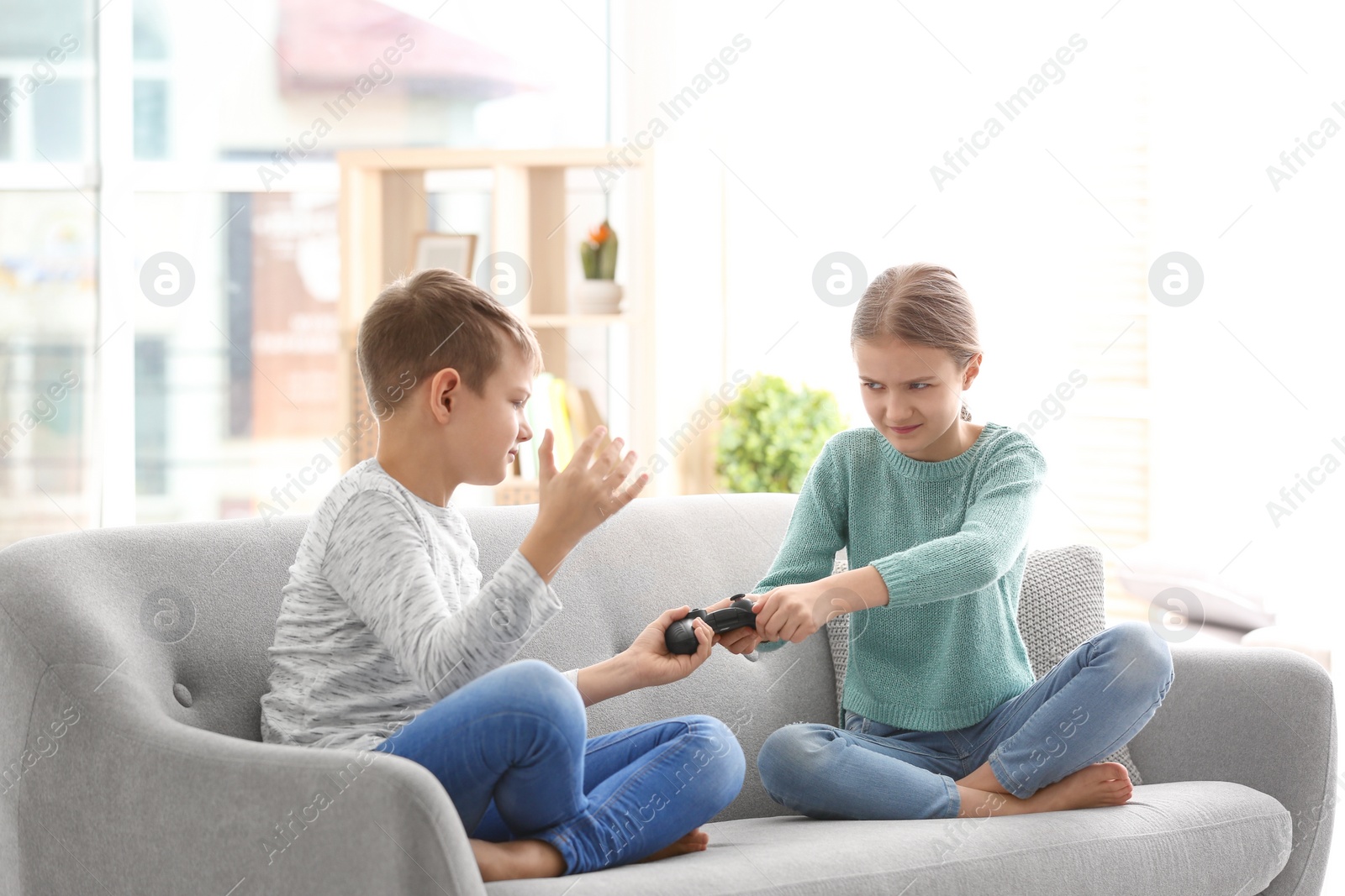 Photo of Brother arguing with sister on sofa at home