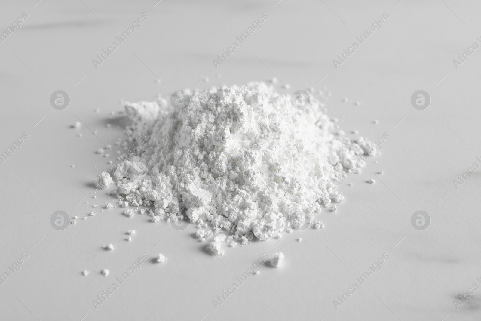 Photo of Heap of calcium carbonate powder on white table