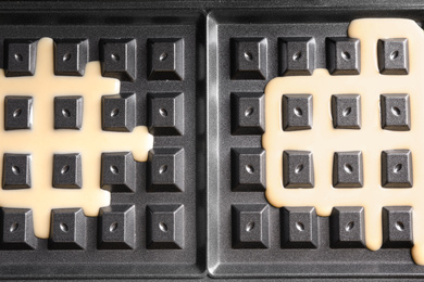 Belgian waffle maker with dough, top view