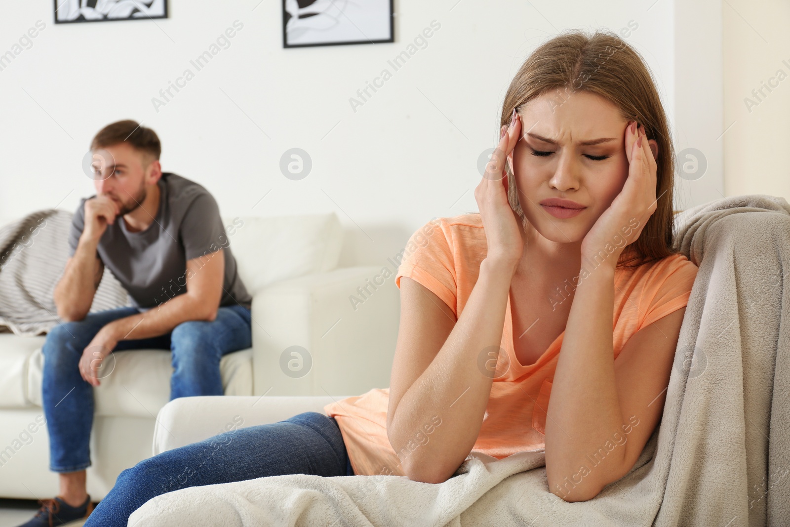 Photo of Young couple ignoring each other after argument in living room. Relationship problems