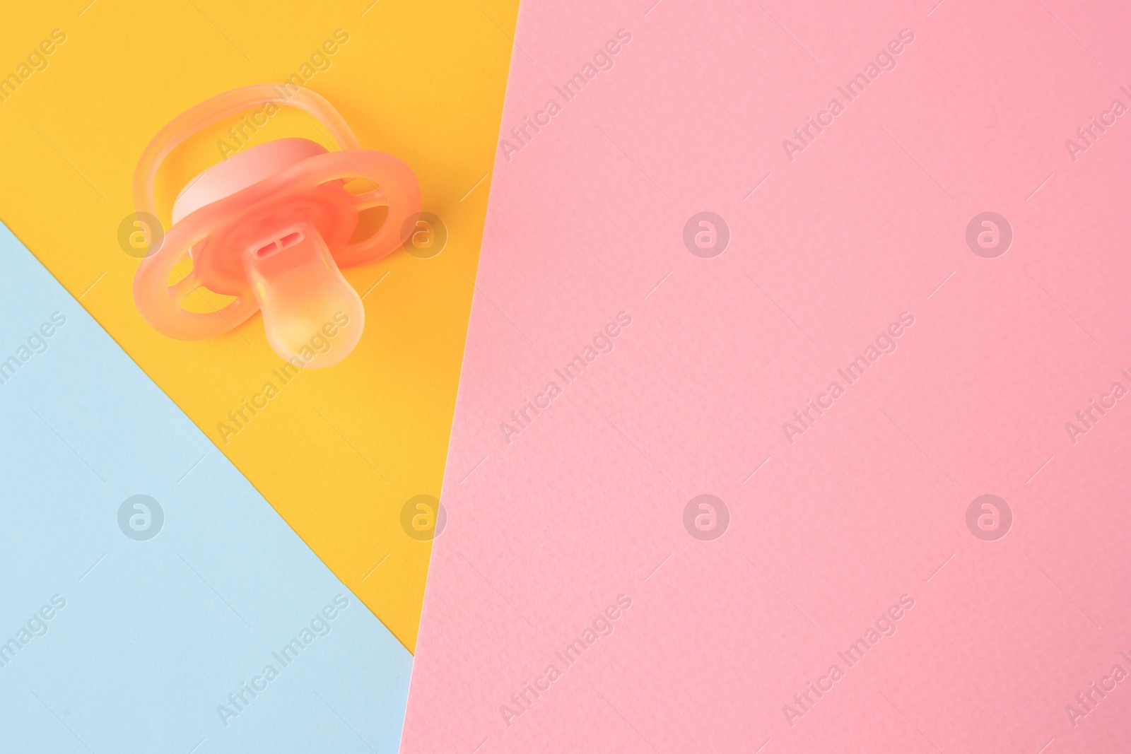 Photo of New baby pacifier on color background, top view. Space for text