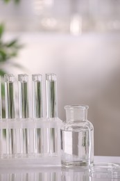 Laboratory analysis. Different glassware with liquid on white table indoors, space for text