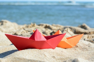Two paper boats near sea on sunny day