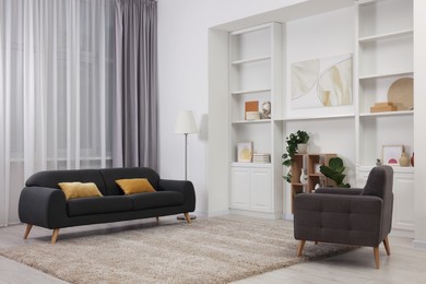 Photo of Stylish room interior with comfortable armchair and couch
