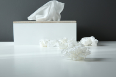 Photo of Used paper tissue and holder on white table, closeup