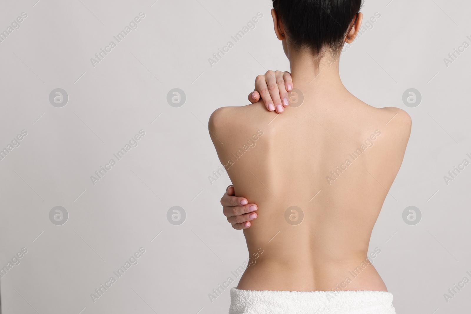 Photo of Back view of woman with perfect smooth skin on light background, space for text