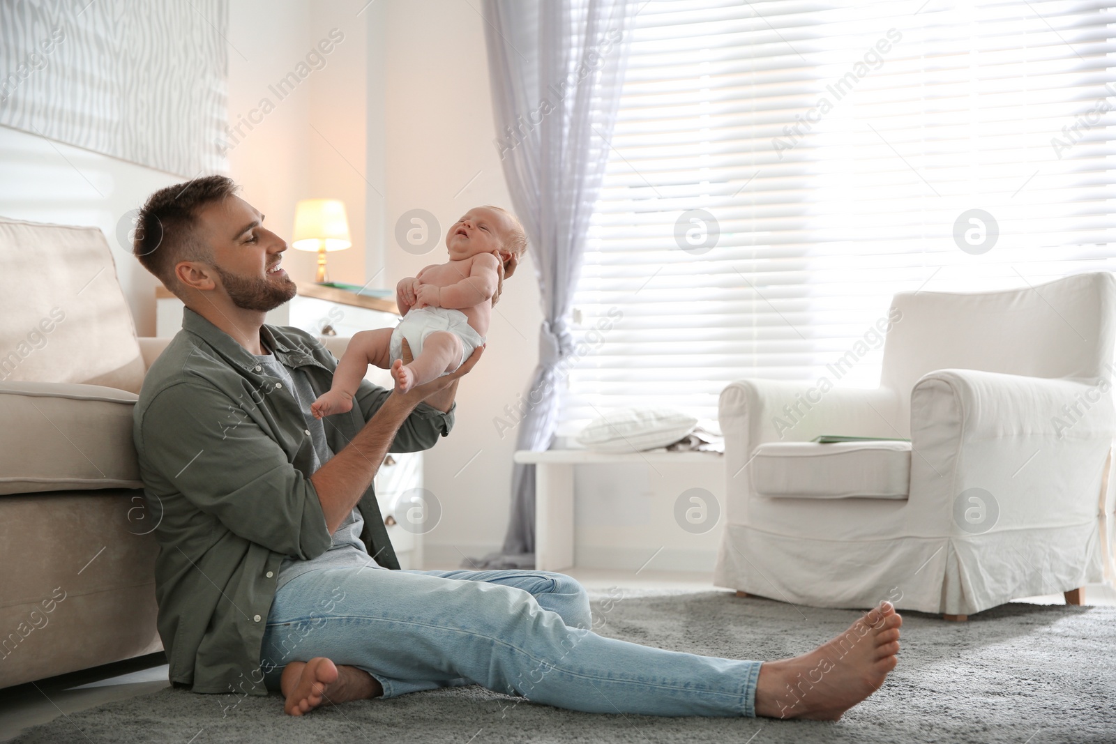 Photo of Father with his newborn son at home