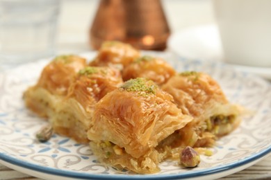Photo of Delicious baklava with pistachios on plate, closeup