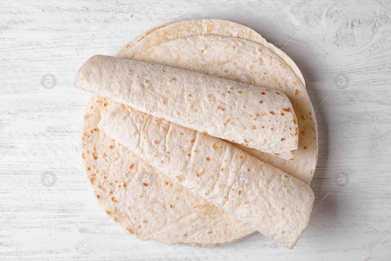 Photo of Corn tortillas on white wooden background, top view. Unleavened bread