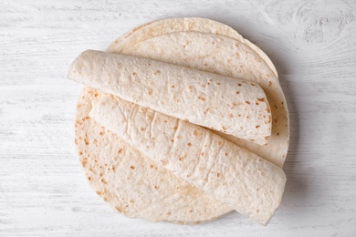 Photo of Corn tortillas on white wooden background, top view. Unleavened bread