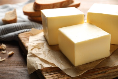 Wooden board with fresh butter on table, closeup