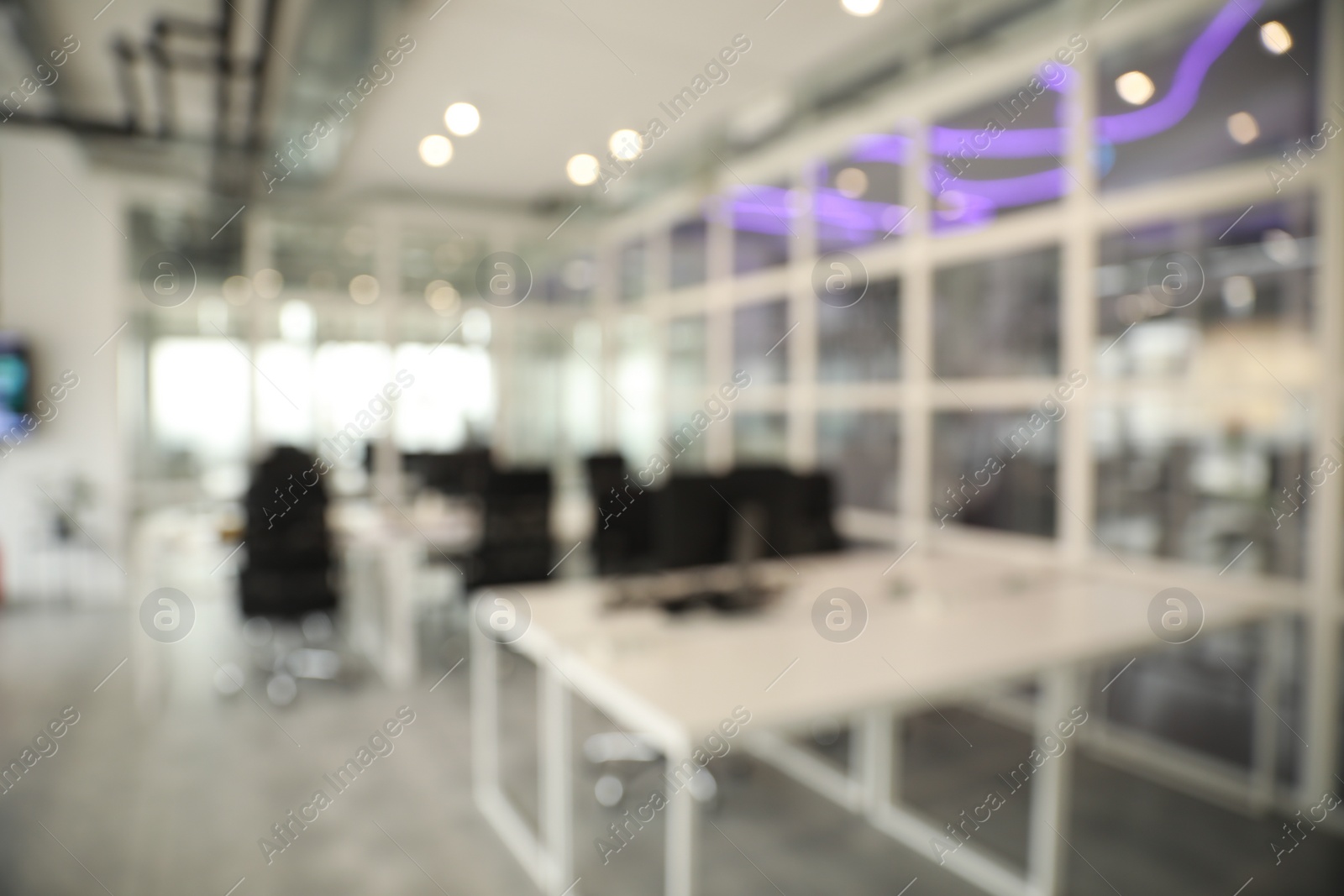 Photo of Blurred view of cozy workspaces with tables and chairs in office