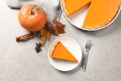 Photo of Flat lay composition with piece of fresh delicious homemade pumpkin pie on gray background