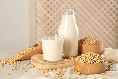 Photo of Fresh soy milk and beans on light grey table