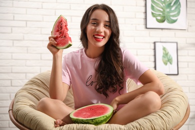 Photo of Beautiful young woman with watermelon at home