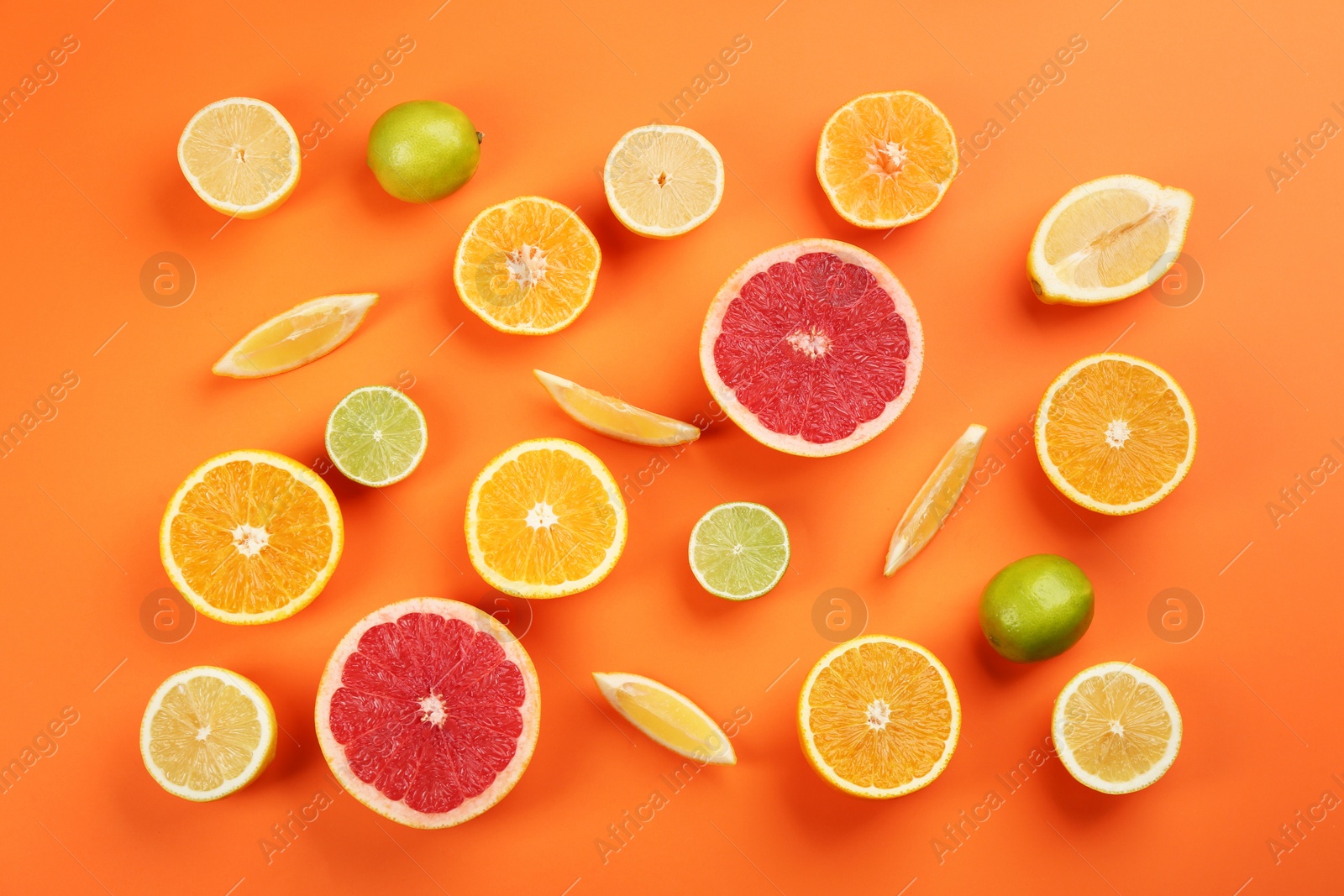 Photo of Flat lay composition with tangerines and different citrus fruits on orange background