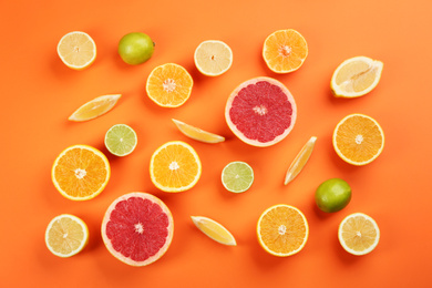 Photo of Flat lay composition with tangerines and different citrus fruits on orange background