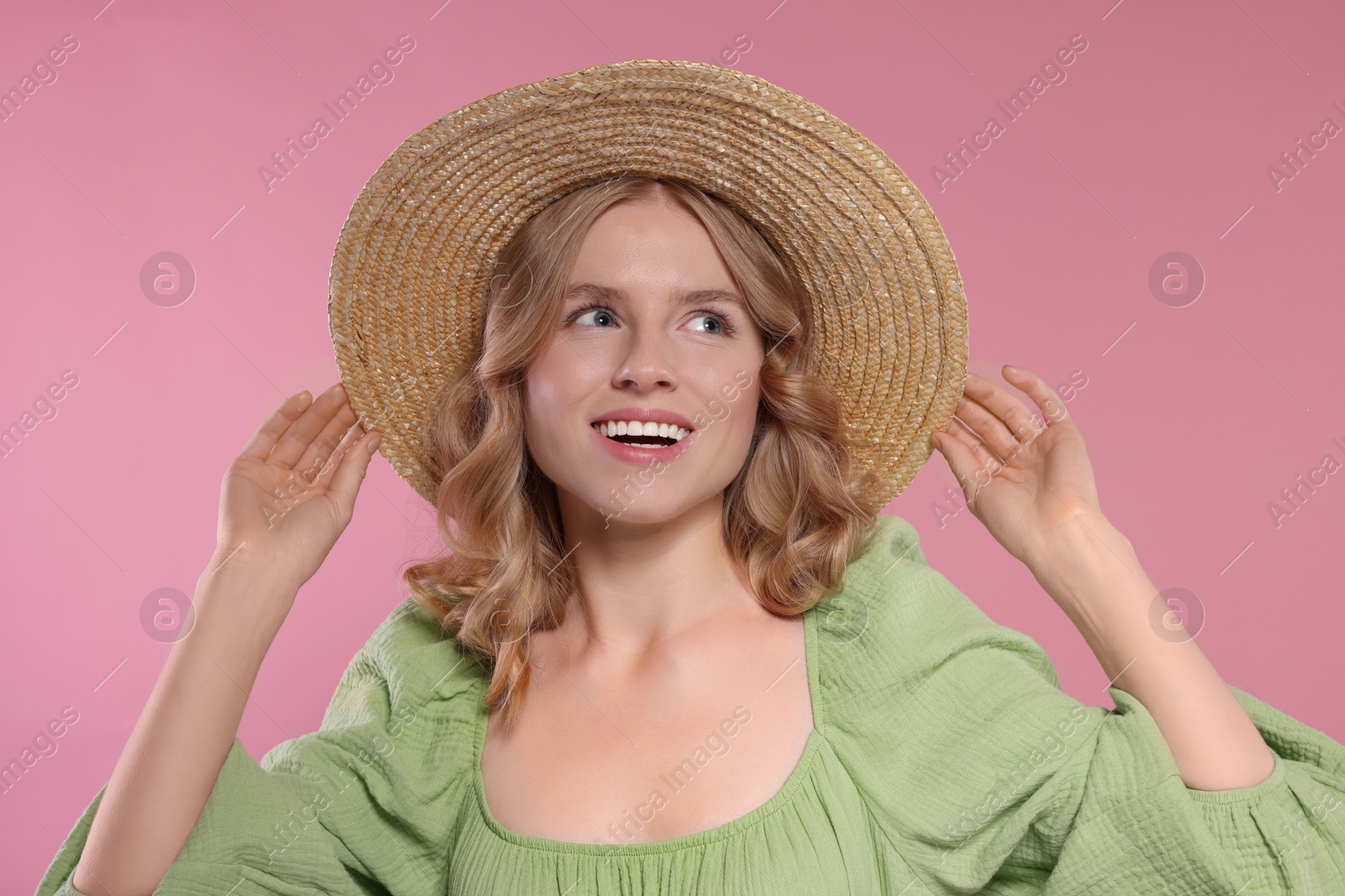 Photo of Portrait of beautiful woman with blonde hair in hat on pink background