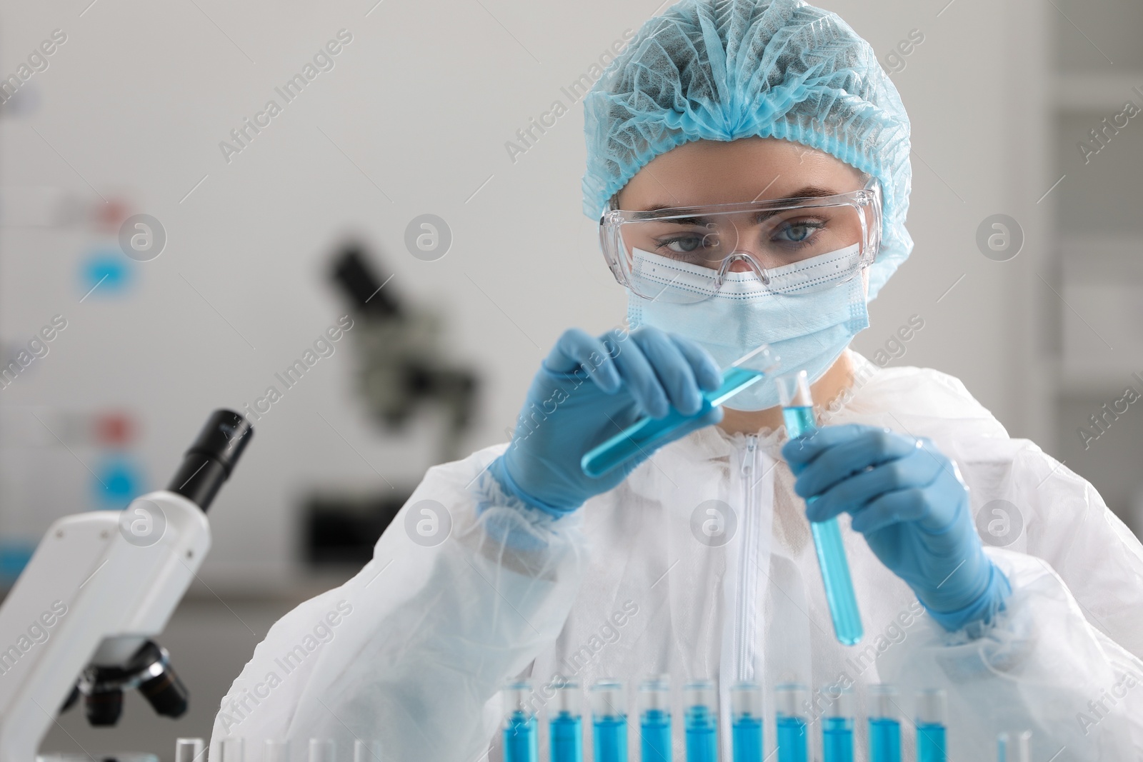 Photo of Scientist pouring sample into test tube in laboratory