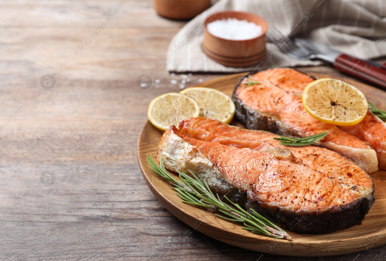 Photo of Tasty cooked red fish on wooden table