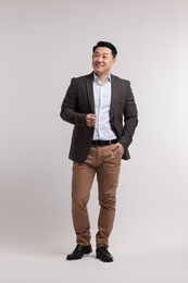 Full length portrait of happy man on light background