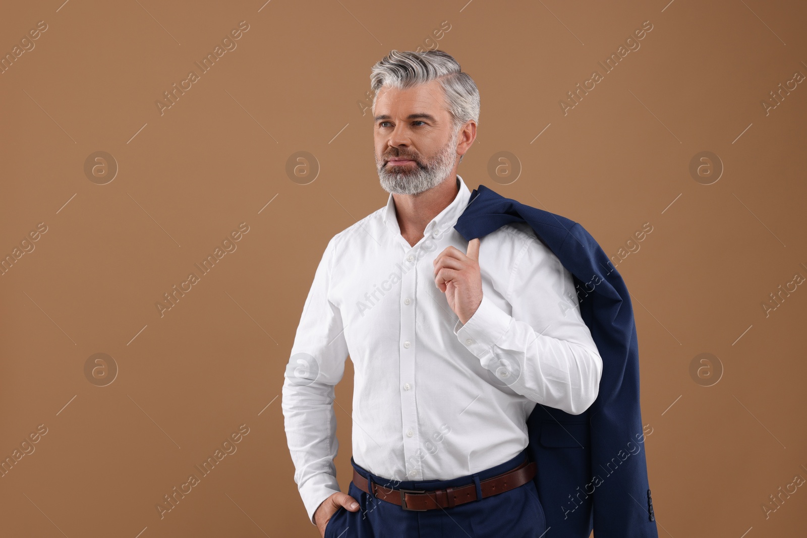 Photo of Portrait of confident man with beautiful hairstyle on light brown background. Space for text