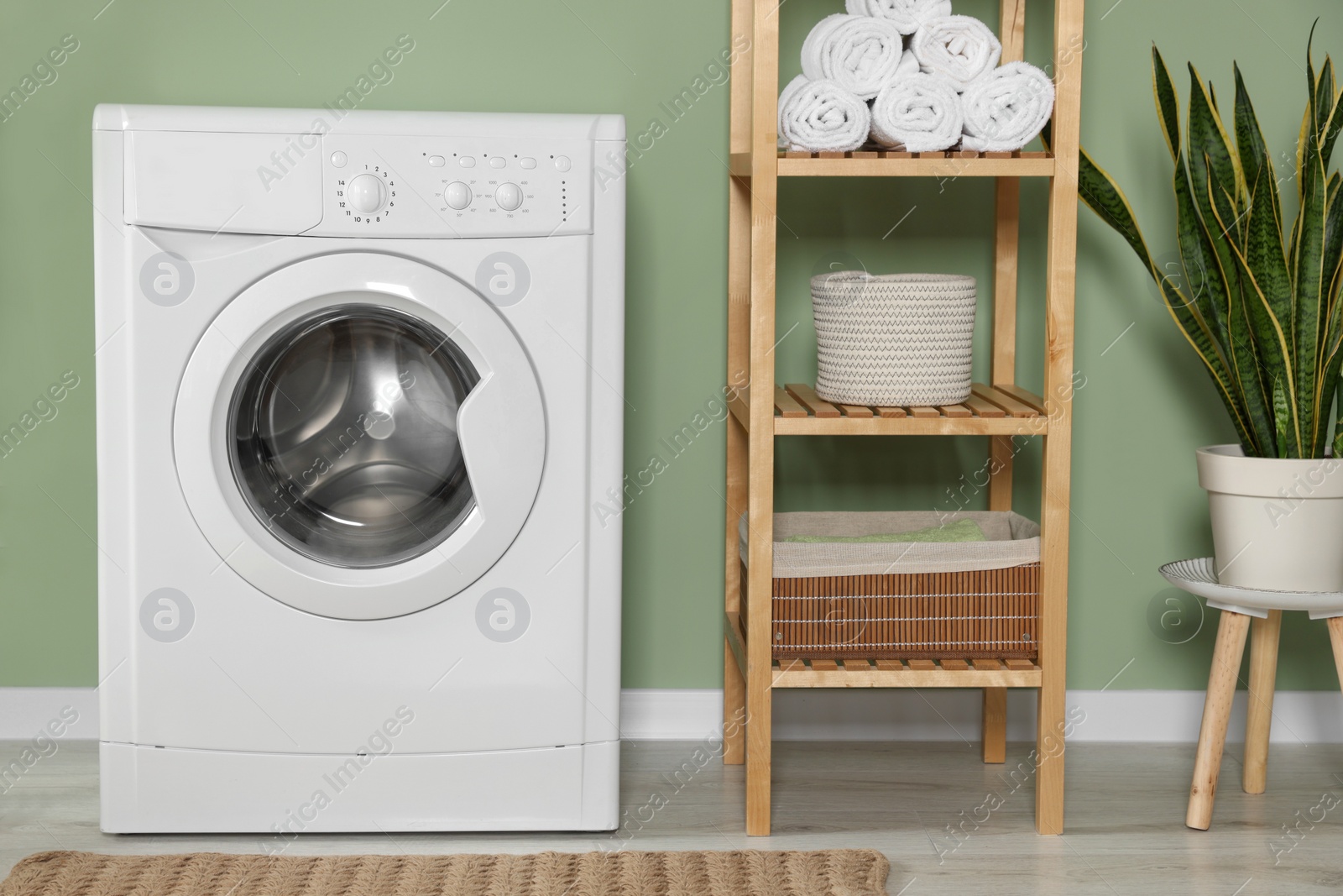 Photo of Stylish laundry room with washing machine. Interior design