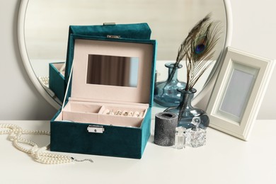 Photo of Jewelry box with many different accessories and decor on white table