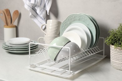 Photo of Many different clean dishware and houseplant on white table indoors