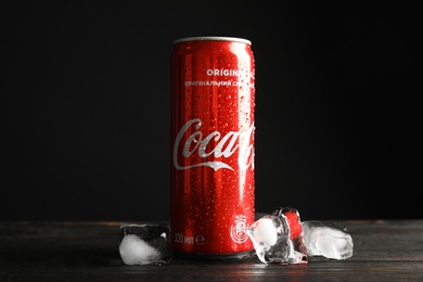 MYKOLAIV, UKRAINE - NOVEMBER 15, 2018: Coca Cola can and ice cubes on table against black background