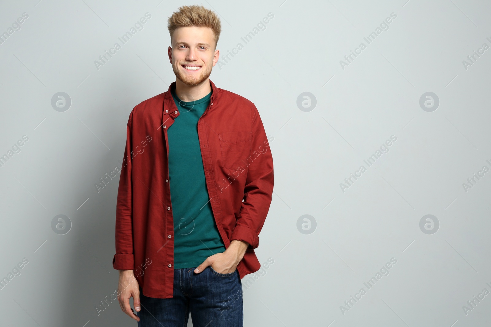 Photo of Young man wearing blank t-shirt on light background. Mockup for design