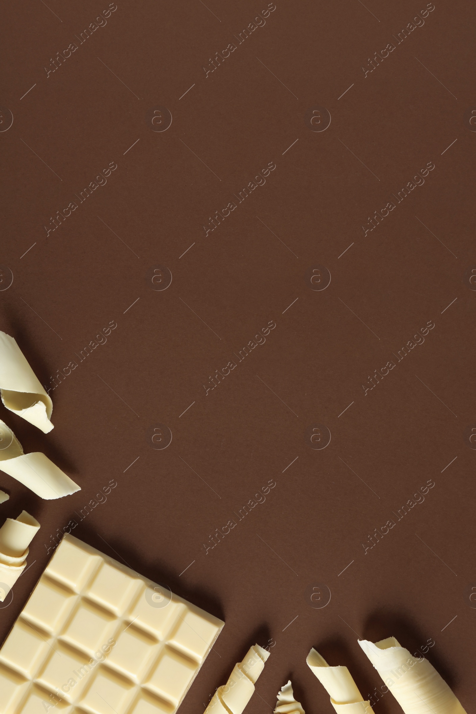 Photo of Flat lay composition with chocolate curls and space for text on color background