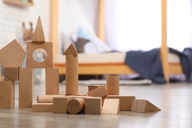 Photo of Wooden toy construction set on floor in child's room, closeup