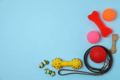 Photo of Flat lay composition with dog leash and toys on light blue background, space for text