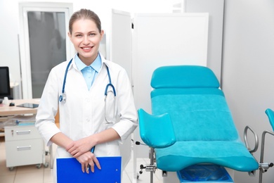 Photo of Portrait of young gynecologist with clipboard at workplace