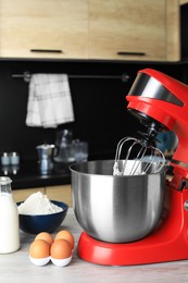 Photo of Modern stand mixer and ingredients on wooden table in kitchen. Home appliance