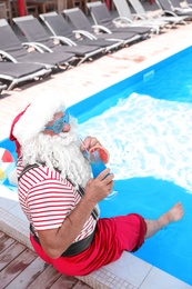 Authentic Santa Claus with cocktail near pool at resort