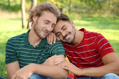 Photo of Portrait of happy gay couple smiling in park