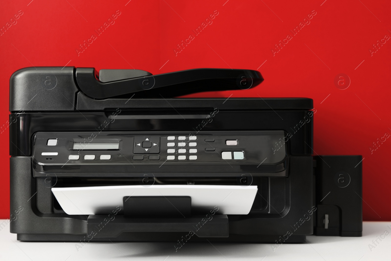 Photo of Modern printer with paper on red background