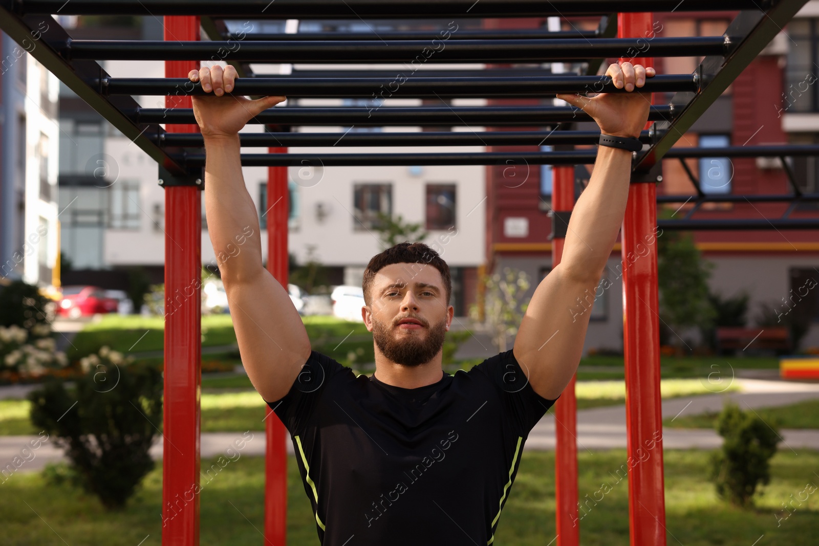Photo of Man training on monkey bars at outdoor gym