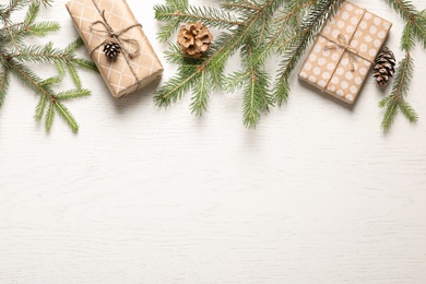 Photo of Flat lay composition with Christmas gifts and fir branches on light background