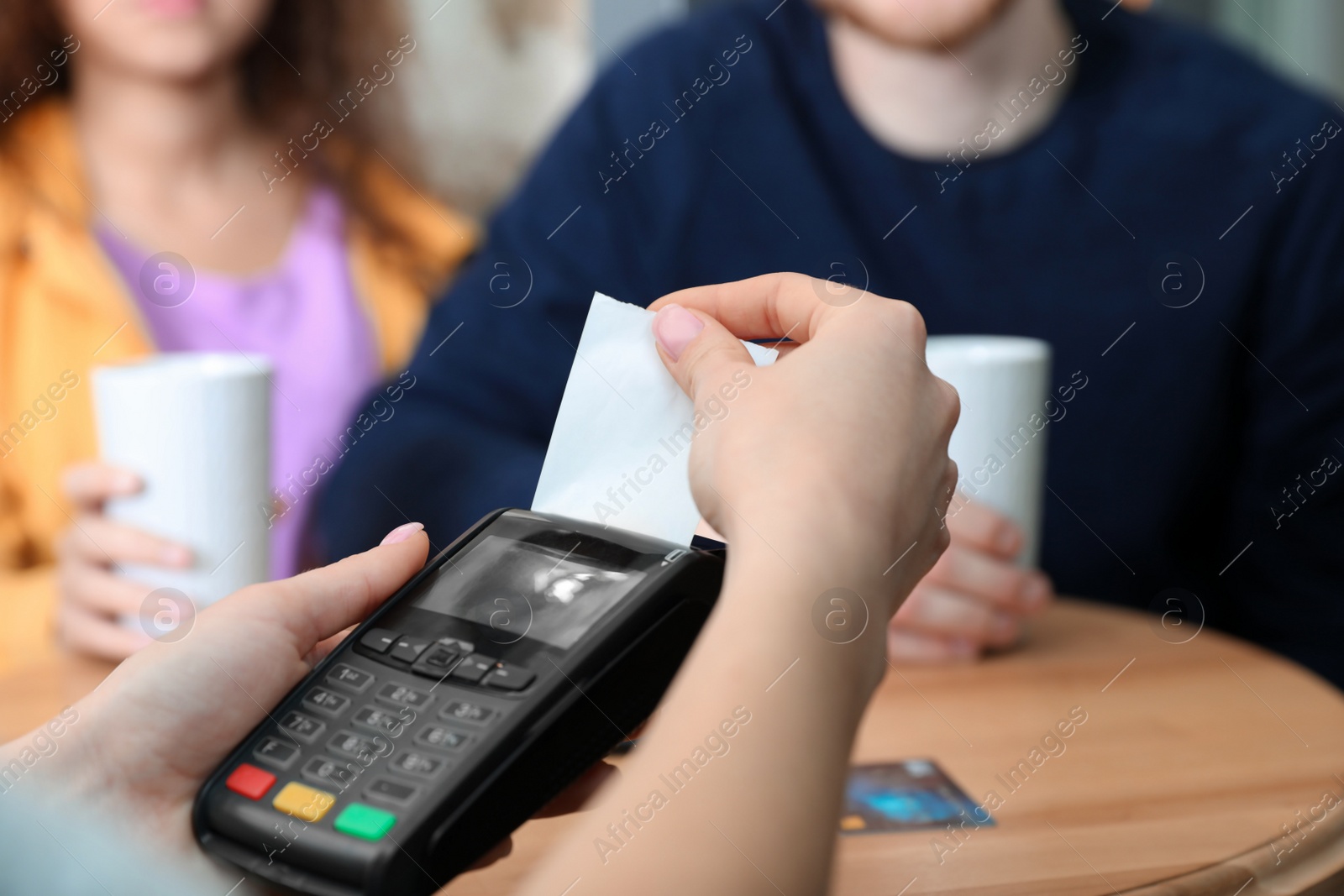 Photo of Clients using credit card machine for non cash payment in cafe, closeup